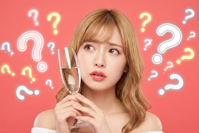 シャンパングラスを持つブロンドの女性とはてなマーク