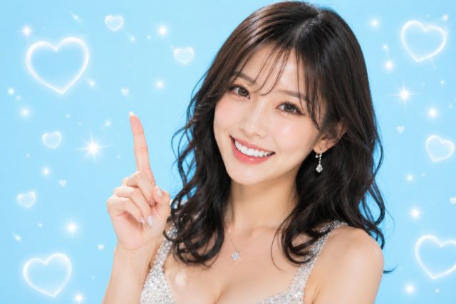 人差し指を立てる笑顔の黒髪女性