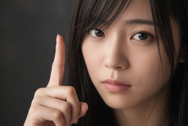人差し指を立てて真剣な顔の女の子
