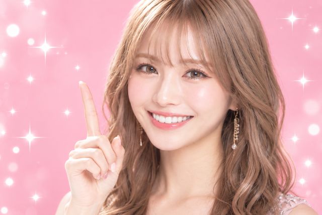 人差し指を立てる笑顔の女性
