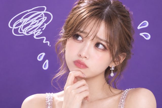 顎に手を当てて困った表情の女性。