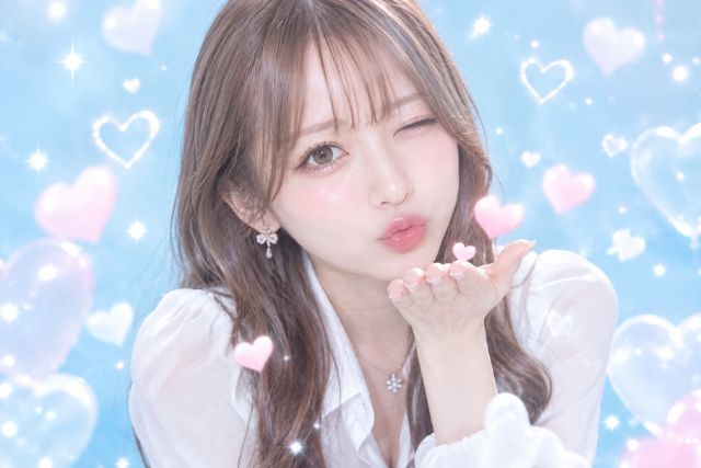 ウインクしながら投げキッスするロングヘアの女性