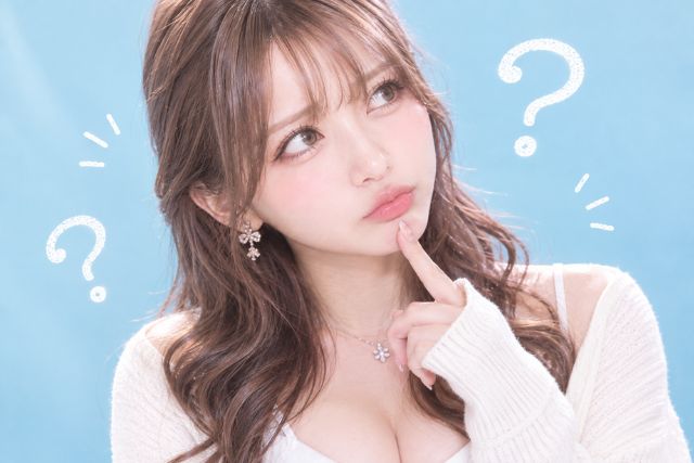 顎に指を当てて首を傾げる女性