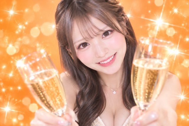 女性がこちらに向かってシャンパングラスを両手で持って乾杯しようとしている