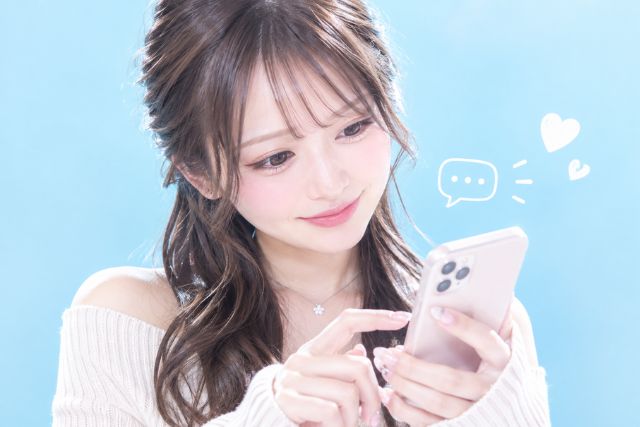 スマホを持って文字を打つ様子の女の子。ちょっと微笑んでいる