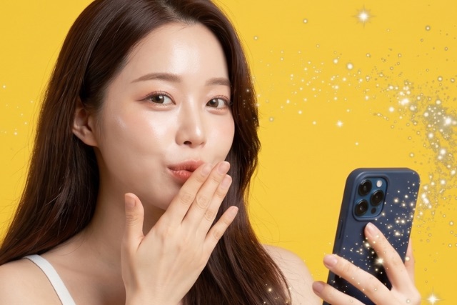 スマホを持って投げキスする女性