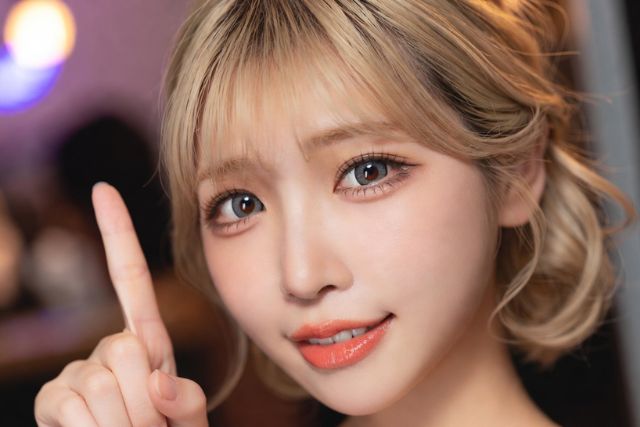 人差し指を立てる金髪の女性