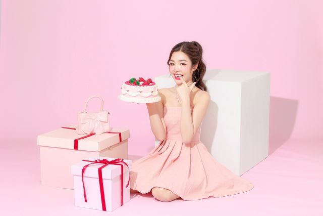 ケーキとプレゼントに囲まれる女性