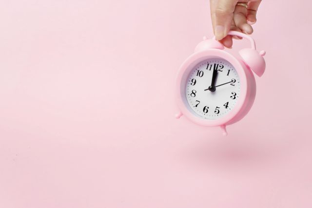 ピンクの背景にピンクの置き時計