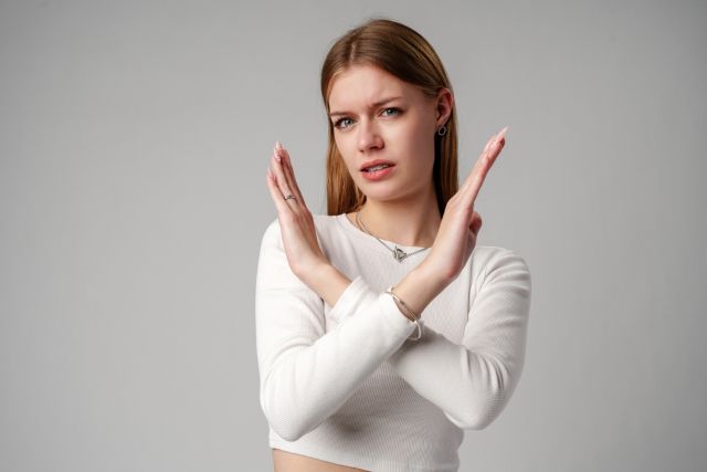 胸の前でバツ印を作る女性