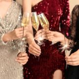 シャンパンで乾杯する3人のドレスの女性