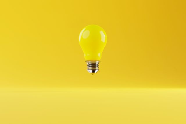 黄色い背景に浮かぶ黄色い電球