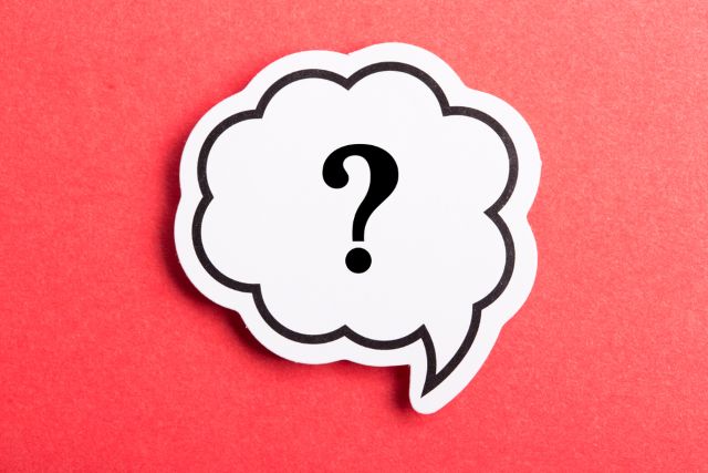 赤い背景の前にあるハテナマークが書かれた吹き出し