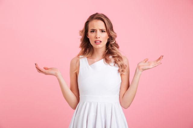 両手を上げて何かに悩む女性