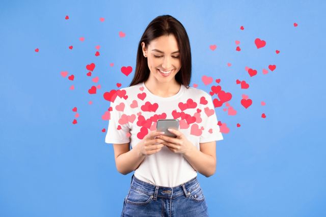 ハートがたくさん飛んでいる携帯を持っている女性