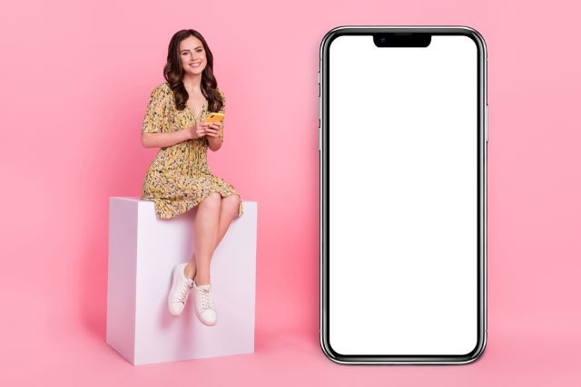 携帯の画面の横に座る女性