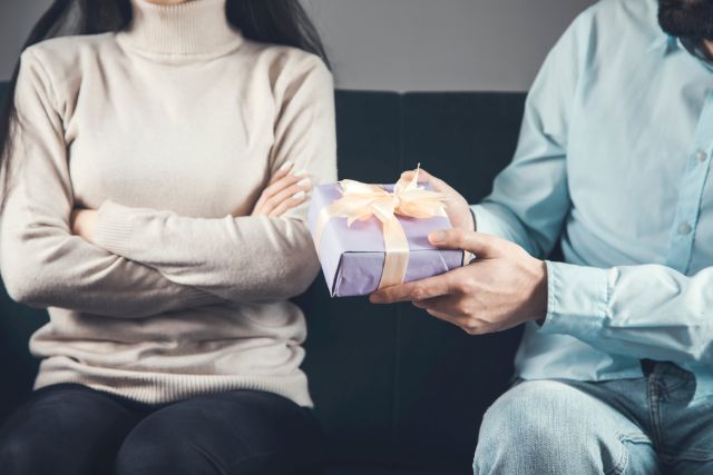 男性からプレゼントをもらう腕を組む女性