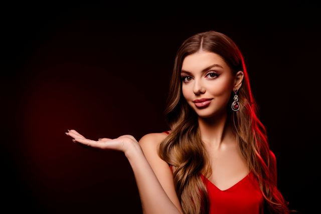 横を手のひらで指す女性