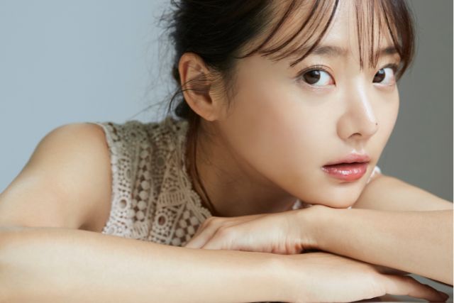 白いドレスを着て肘をつく女性