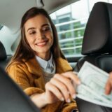 タクシーでお金を渡す女性