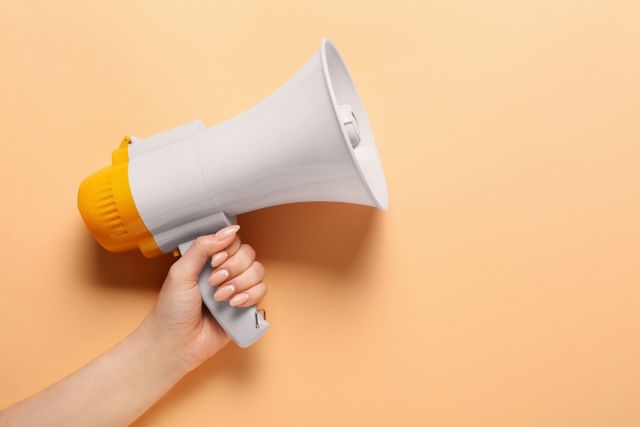 メガホンを持つ女性の手