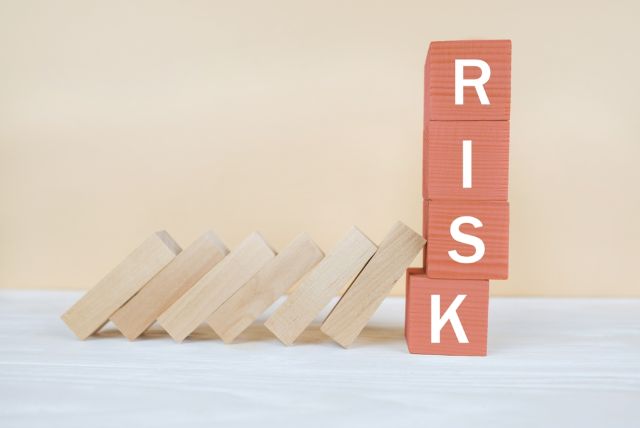 RISKと書かれたブロックに倒れ掛かる積み木