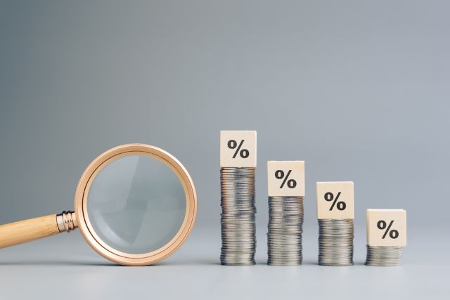 虫眼鏡とパーセントが書かれたブロックがのっているコイン