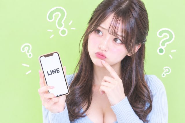 携帯を持ちながらハテナマークを浮かべる女性
