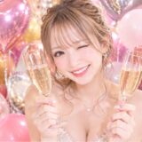 シャンパングラスを両手に持って笑顔の女の子。後ろにはバルーンの装飾
