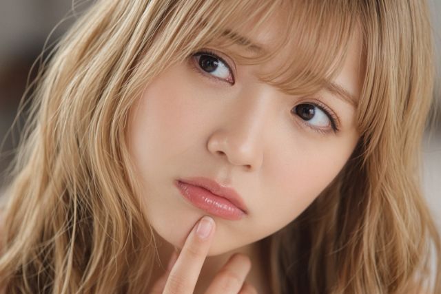 口に指を当てて不安そうな表情の女性