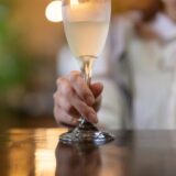 シャンパングラスをカウンターに置く女性