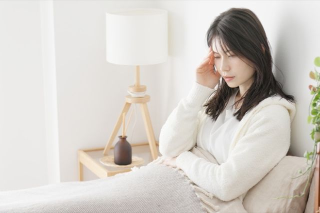 朝、頭が痛そうにしている女性