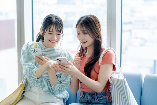 笑顔でスマホを見ている女性