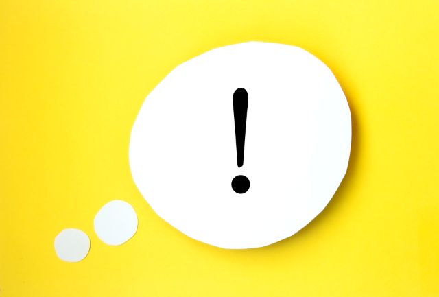 黄色の背景の前にあるビックリマーク