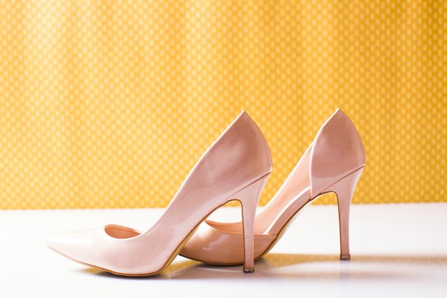 黄色の背景の前にあるピンクのヒール