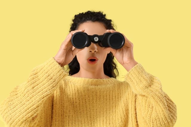 双眼鏡で除く女性